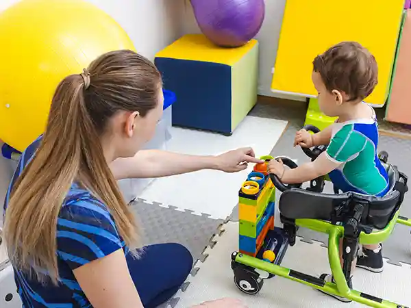 Child with cerebral palsy working with a physical therapist on mobility and muscle strength training