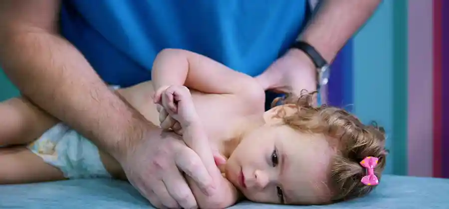 Pediatrician evaluating a child for cerebral palsy symptoms during a developmental checkup
