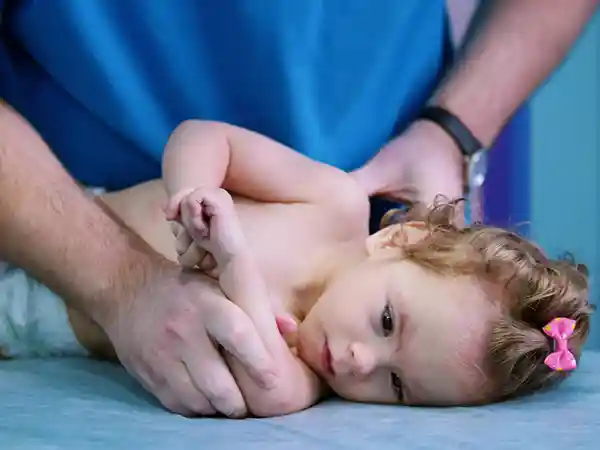 Pediatric physical therapist working on arm range-of-motion exercises with an infant who has Erb's palsy