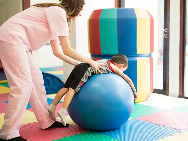 Child undergoing constraint-induced movement therapy (CIMT) with an occupational therapist for cerebral palsy