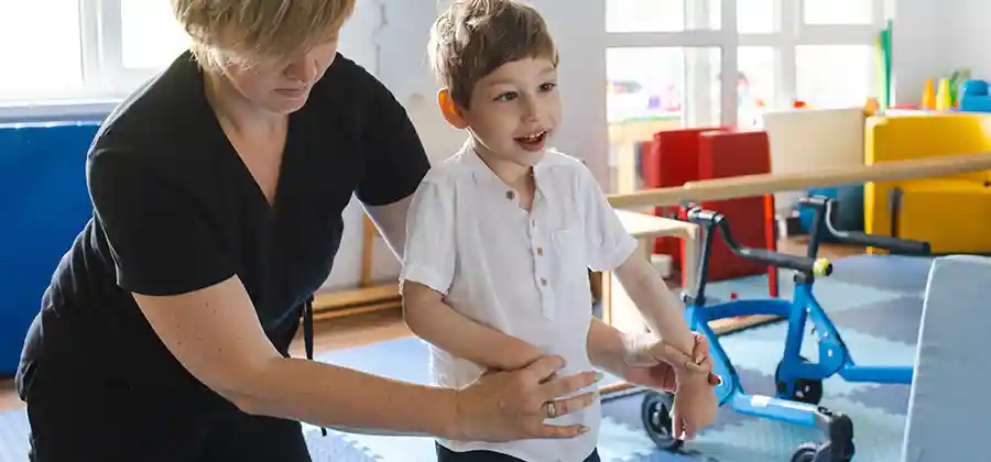 Child with cerebral palsy working with a physical therapist on gait training and mobility exercises