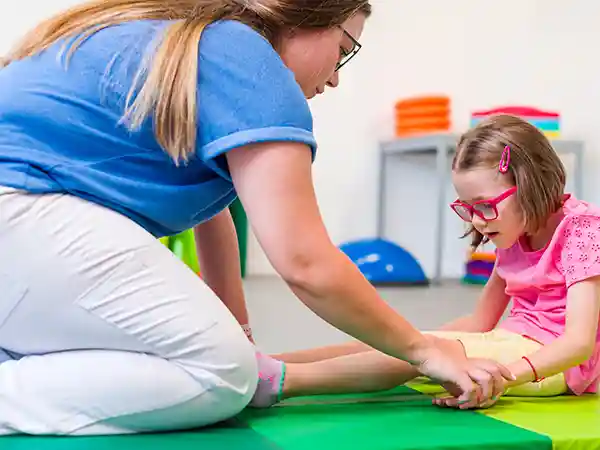 Child with spastic cerebral palsy working with a physical therapist on mobility and muscle tone exercises